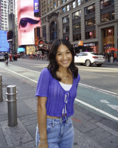 A woman wearing a purple top, smiling. 